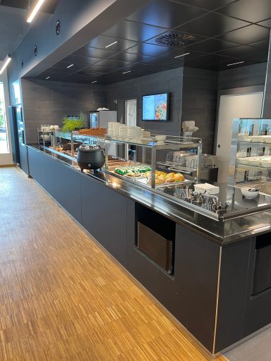 Moderne Buffetstation mit Speisen und Getränken in einem hellen Restaurant.